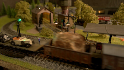 Miniature signalman and cargo train. Retro railway station.