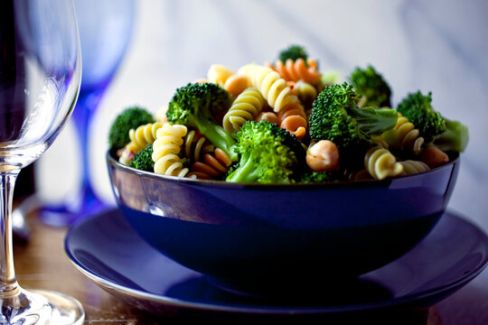 Pasta with broccoli and chickpeas in blue bowl