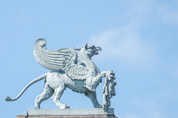 Closeup of an old statue of medieval griffin, a hybrid of lion and bird, on the top of the State...