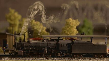 Lokomotive model with smoke. Miniature train on a railway.