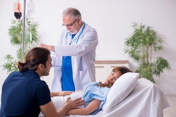 Fototapeta premium Young husband visiting sick wife in the clinic