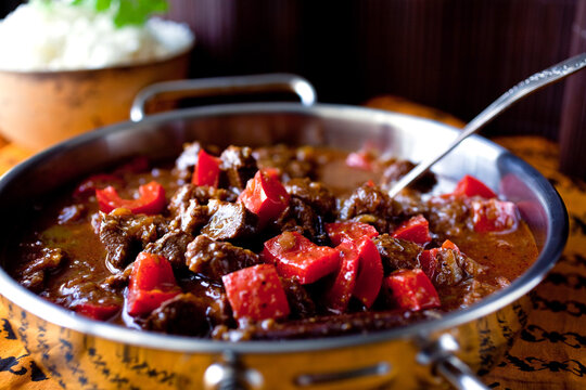 Pork vindaloo in silver pot with spoon