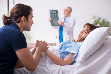 Fototapeta premium Young husband visiting sick wife in the clinic