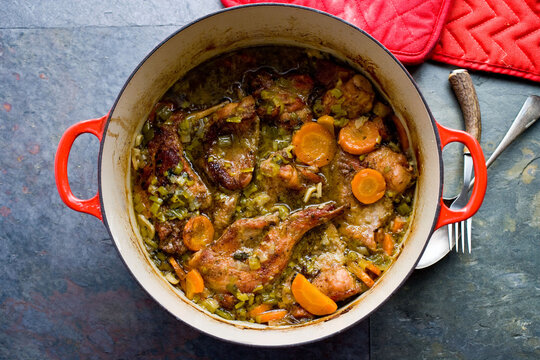 Close up of braised rabbit with carrots in pot
