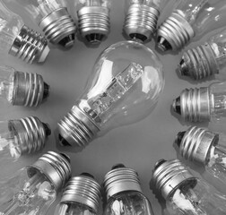 tungsten filament lamp and many lamp bulbs lie around. brainstorming idea.