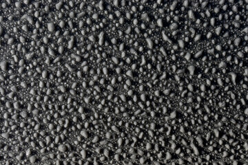 Fototapeta premium Texture of frozen water drops on a matte surface. Freezing rain. Frost on the glass. The rocky surface. Stones. Pimples.