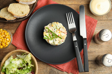 Delicious salad with crab sticks served on wooden table, flat lay