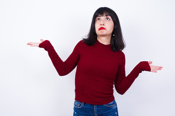 Beautiful young Caucasian woman standing against white background having doubt expression, confuse...