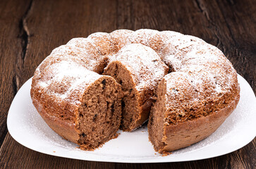 A ring-shaped cupcake sprinkled with powdered sugar.