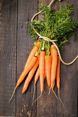 Fresh carrots bunch on rustic background. Healthy vegan vegetable food.