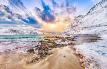Fantastic winter view of  Haukland beach during sunset with lots of snow  and snowy  mountain peaks...