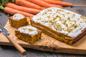 A  carrot cake with fresh carrot on wooden background