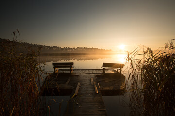ławeczki o wchodzie słońca nad jeziorem 