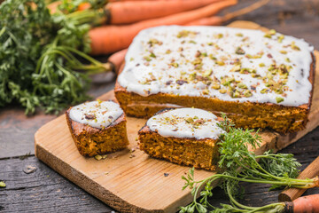 A  carrot cake with fresh carrot on wooden background