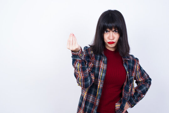 What the hell are you talking about. Shot of frustrated Beautiful young Caucasian woman gesturing with raised hand doing Italian gesture, frowning, being displeased and confused with dumb question.