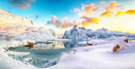 Fantastic frozen Flakstadpollen and Boosen fjords and reflection in water during sunrise with...