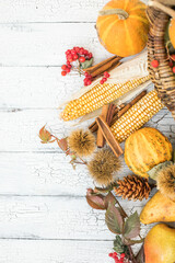 Festive autumn decor from pumpkins, berries and leaves on a white wooden background. Concept of Thanksgiving day or Halloween. Composition with copy space.