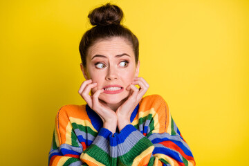 Photo of impressed scared brunette girl look empty space wear rainbow sweater isolated on bright yellow color background