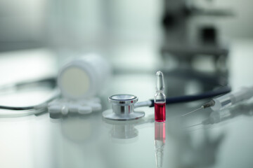 Stethoscope ampoule pill microscope syringe on glass table