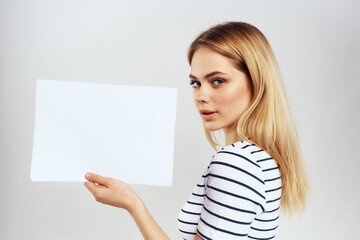 Naklejka premium woman holding a sheet of paper in her hands lifestyle striped t-shirt cropped view Copy Space