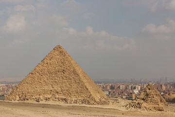 Fototapeta na wymiar A picture of four of the great historical pyramids of Giza in the light of day, the pyramid of King Menkaure and the small pyramids next to it, one of the Seven Wonders of the World, Giza - Egypt