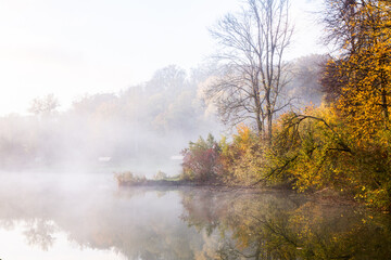 Beautiful landscape with lake and forest. Amazing nature wallpaper. Autumn trees in foggy morning. Romantic place. 
