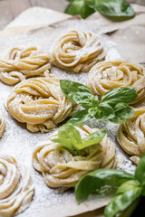 Pasta alluovo, Tagliatelle or fettuccine. Round balls of raw pasta on the wooden cutting board on black background