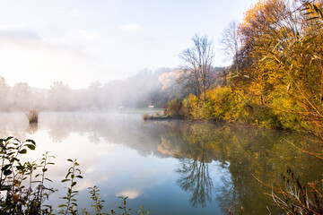 Beautiful landscape with lake and forest. Amazing nature wallpaper. Autumn trees in foggy morning. Romantic place. 