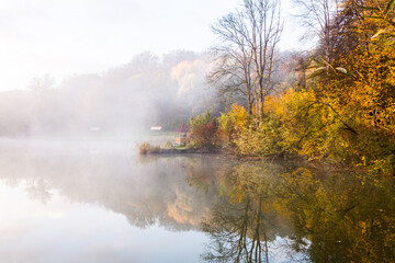 Beautiful landscape with lake and forest. Amazing nature wallpaper. Autumn trees in foggy morning. Romantic place. 