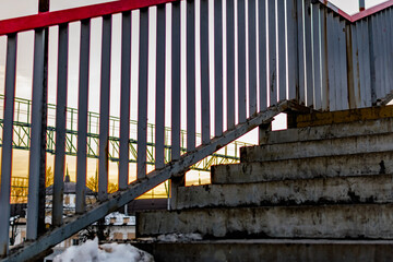 Dirty, trampled concrete steps with metal railings on each side. Old built structure for walking. Ascent and descent in the open air on the street.
