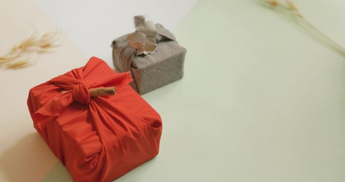 Young woman hands organizing 3 colored gifts wrapped in cloth, Christmas and New year minimalist concept. 4k