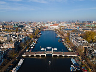 Obraz premium Amsterdam, The Netherlands, 7th November 2020 Aerial view of the Magere Brug Amsterdam And the river Amstel, City hall and Hermitage autumn