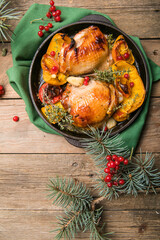 Roasted Christmas Chicken  thighs with pumpkin   for Christmas Dinner. Festive decorated wooden table
