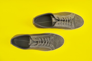 New men's leather gray sneakers on yellow background, top view