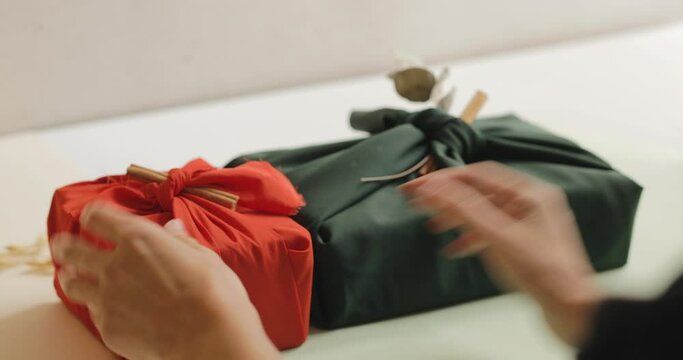 Young woman stacking wrapped gifts on a table, Christmas and New year minimalist concept. 4k