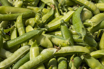 Pea pods are spread out on the surface.