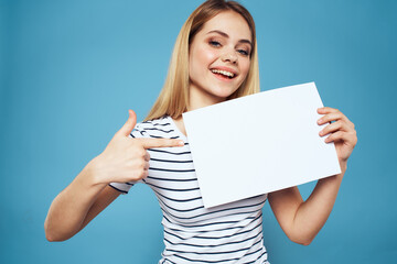Emotional woman holding a sheet of paper in her hands lifestyle close-up blue background Copy Space