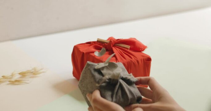 Woman selecting wrapped gift on a table, Christmas and New year minimalist concept. 4k
