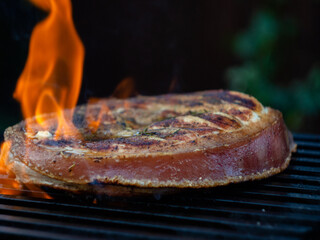 flambe on the grill. cooking a steak with a pork leg bone on the fire.