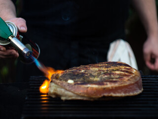 a man burns meat with a gas burner on the grill.