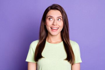 Photo of very nice cheerful young girl looking empty space toothy isolated on vivid violet color background