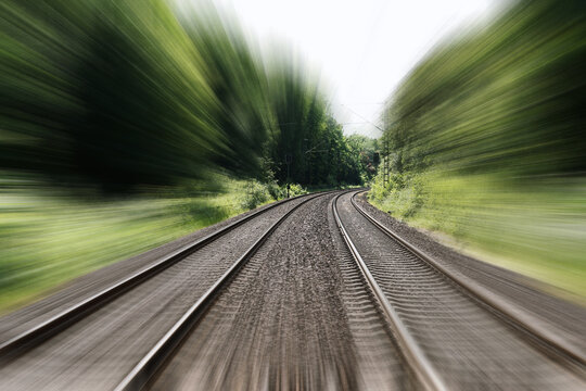 double-track railroad railway or train tracks with speed motion blur - fast travel concept background with copy space