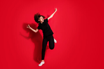 Photo portrait full body view of crazy girl dancing standing on one leg isolated on vivid red colored background