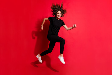 Fototapeta na wymiar Photo portrait full body view of woman running jumping up isolated on vivid red colored background