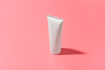 Blank white tube design on a pink background. Mockup