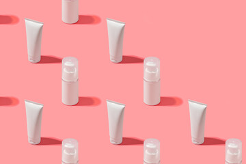 Trendy sunlight beauty pattern made with Blank white tube cream on bright light pink background, copy space, mock up