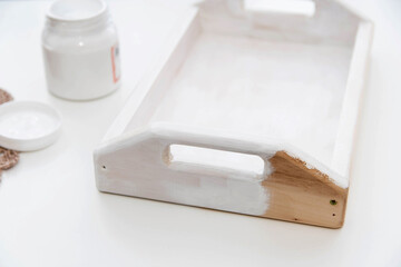 Painting the wooden tray white. Home creativity concept.