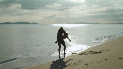 Couple concept.The silhouette of the young woman on the back of a young man walking and spinning on the beach.
- Powered by Adobe