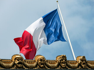 National flag of France against a blue sky.