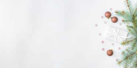 Flat lay frame with fir branches, christmas baubles decoration and gift box on a white background